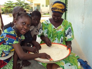 A family cleaning rice in a large bowl