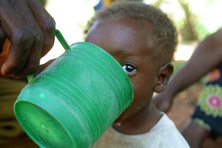 Picture of boy drinking water out of green cup in Kongolo 