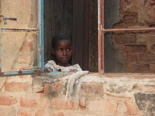 Girl in Bindura looking through an opened window Girl in Bindura looking through an opened window